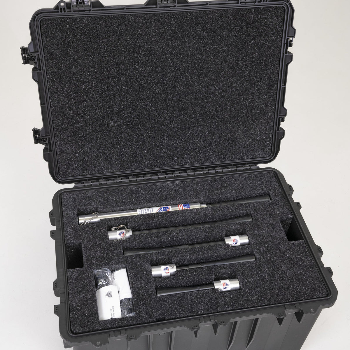 The transport case open with tee uprights and fittings seated in their foam cutouts.