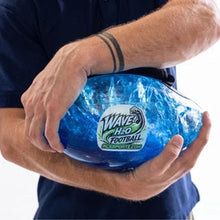 Player hugging the water-filled football against his body with the blue water swirling inside the clear shell