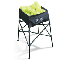 The black JUGS Back-Saver ball basket on its folding legs, filled with yellow softballs, on a white background.