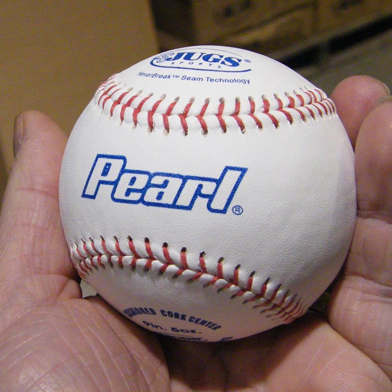 A JUGS Pearl leather baseball held in a hand.