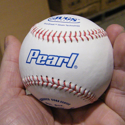 A JUGS Pearl leather baseball held in a hand.