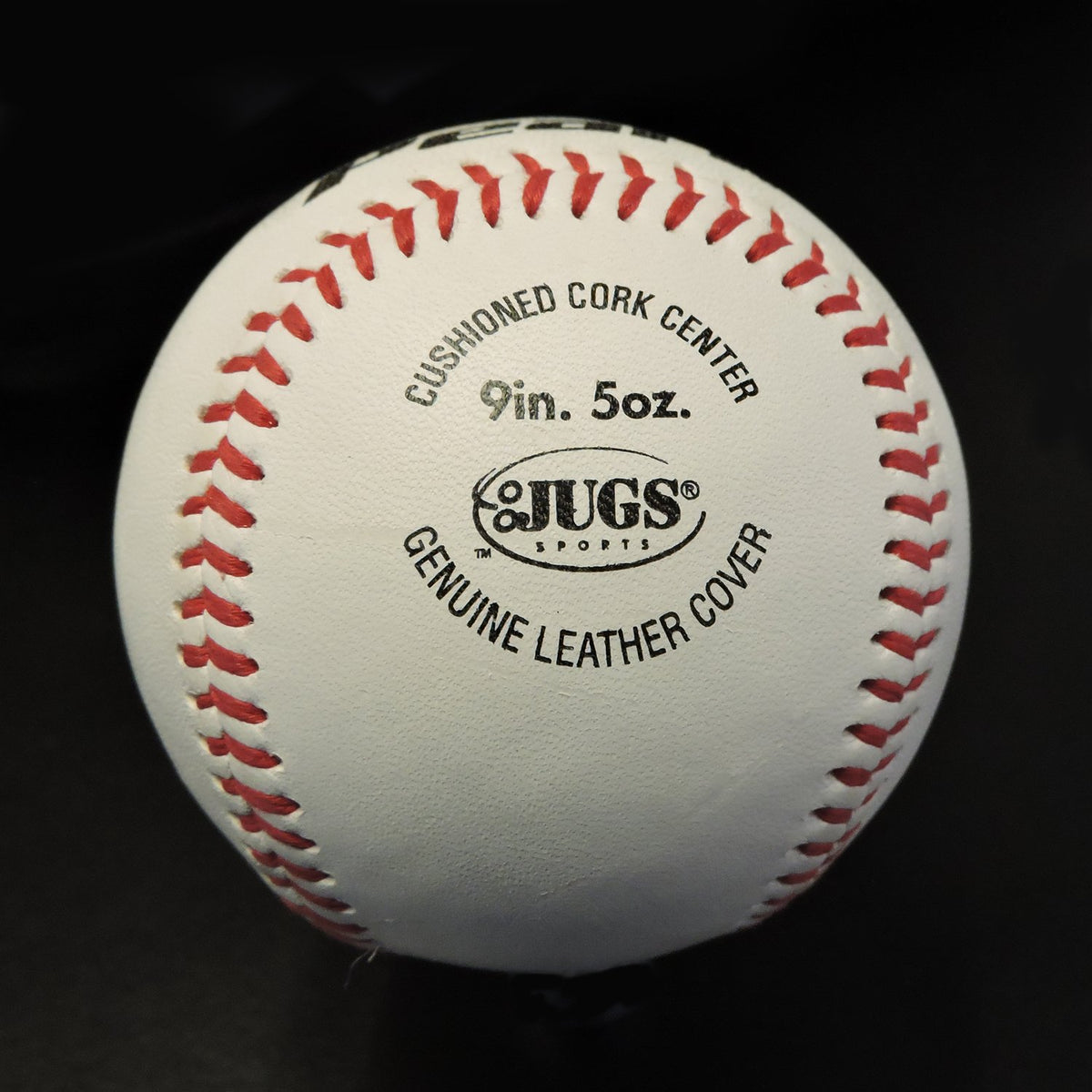 A JUGS Youth League Pearl baseball showing its cushioned cork center and genuine leather cover stamp.