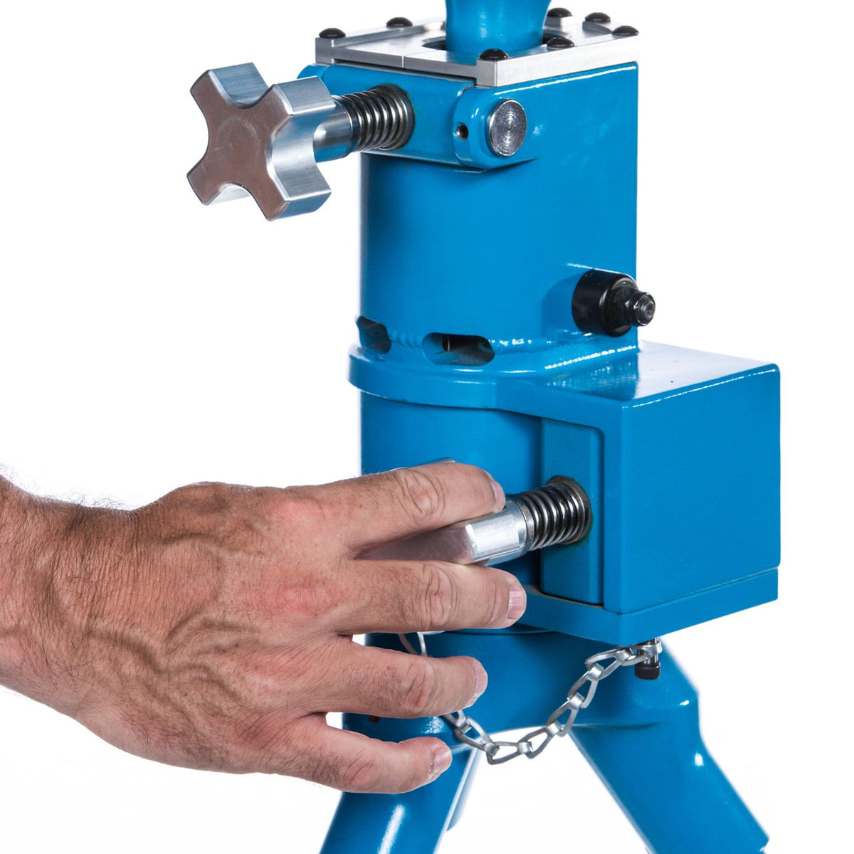 A hand tightening the locking knob on the JUGS BP3 base column, with the safety chain attached below.