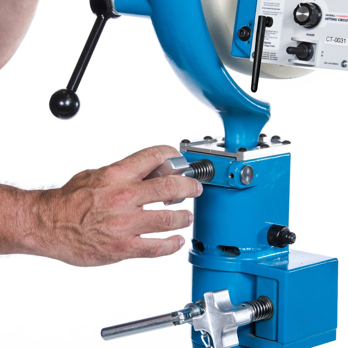 A hand turning the micro-adjustment knob on the head of the JUGS BP3 to fine-tune pitch location, with the elevation handle above.