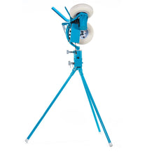 Side view of the JUGS BP3 baseball pitching machine on its tripod legs, showing the long feed chute and two of the three wheels, photographed on a white background.