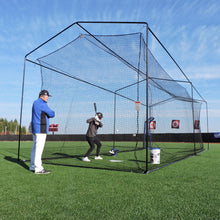 A coach and a young hitter inside the JUGS Free-Standing 35-Foot Batting Cage on a turf field.