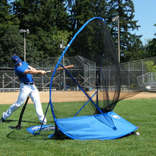 A baseball player hitting a ball into the JUGS Instant Screen on a grass field.