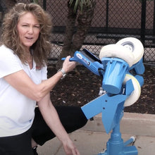 Michele Smith demonstrating the JUGS mini3 Softball Pitching Machine outdoors.