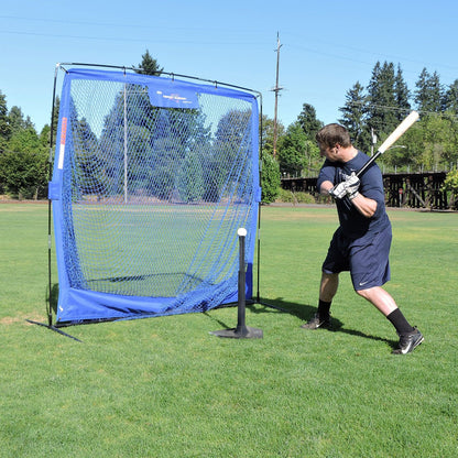 A baseball player hitting off the JUGS Hit Like a Pro Hitting Tee into the JUGS Complete Practice Travel Screen on a grass field.
