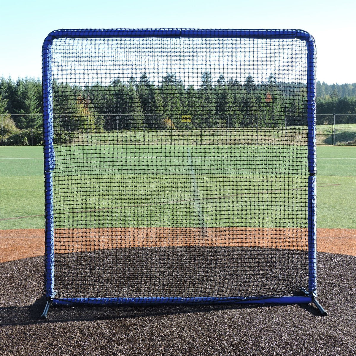 The JUGS Protector Blue Series 8-Foot Fungo Screen standing on a pitcher's mound.