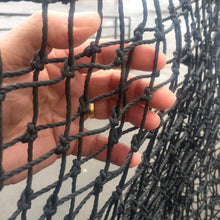 A hand holding the knotted polyester netting used on JUGS Protector Blue Series screens.