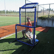 A coach seated behind the JUGS Protector Blue Series Short-Toss Screen in an outdoor batting cage.