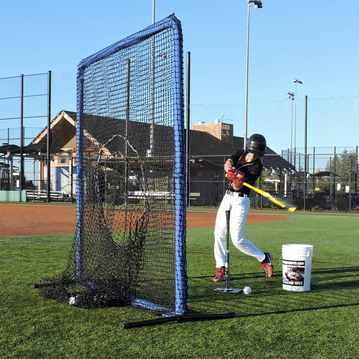 A baseball player hitting into the sock net of the JUGS Protector Blue Series Square Screen.