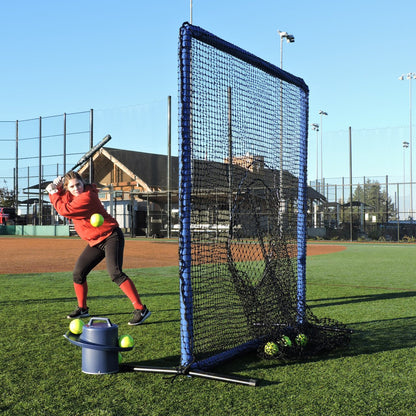A softball player hitting into the JUGS Protector Blue Series Square Screen with Sock-Net next to a ball bucket.