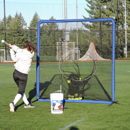 A softball player swinging at the JUGS Protector Blue Series Square Screen with Sock-Net on a turf field.