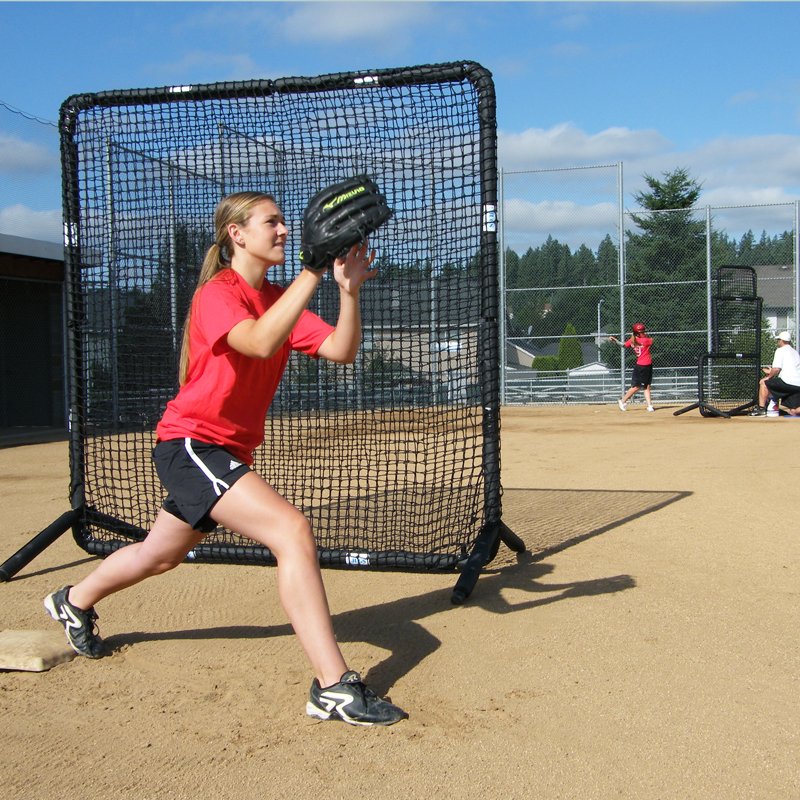 A softball fielder catching a throw in front of the JUGS Protector Series Square Baseman Screen.