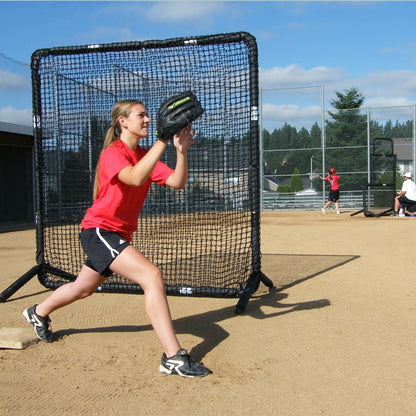 A softball fielder catching a throw in front of the JUGS Protector Series Square Baseman Screen.