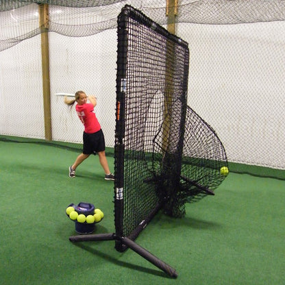 A softball player hitting into the sock net of the JUGS Protector Series Square Screen inside an indoor facility.