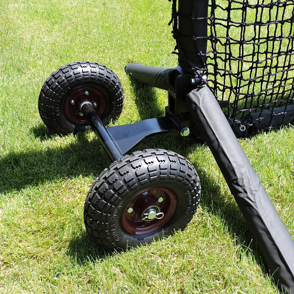 Close-up of the JUGS Protector Series Wheel Kit attached to the base of a screen on grass.