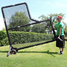 A man tilting a JUGS Protector Series L-Shaped Screen onto its wheel kit to roll it across grass.