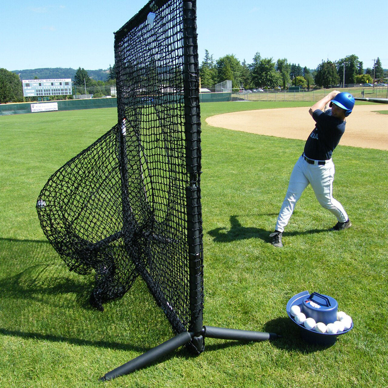Young baseball player hitting balls into a sock net