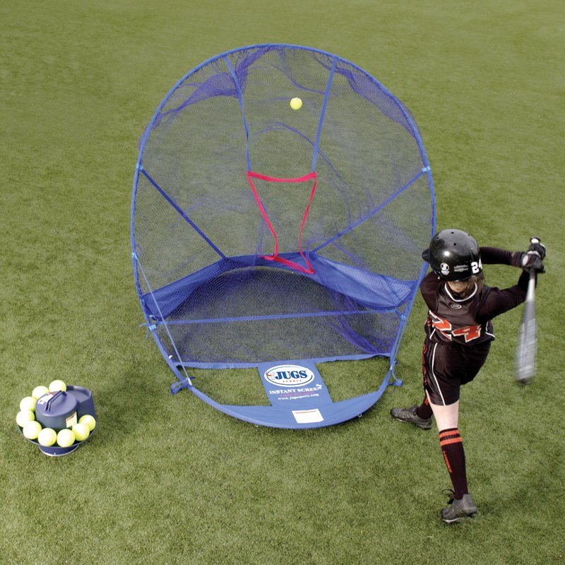 A young batter beside a JUGS Toss Machine loaded with yellow balls, hitting into a blue pop-up net with a red target, viewed from above on grass.