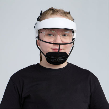 A young softball player with short blond hair and glasses wearing the white fielder's mask and a black T-shirt, facing the camera against a pale gray background.