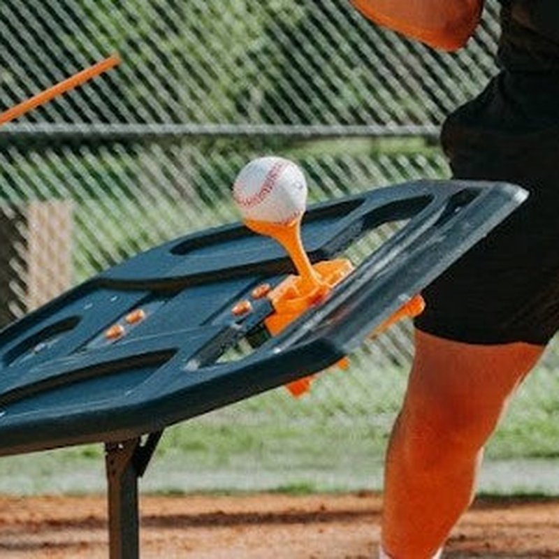The ball topper on the Swing Path Trainer holding a baseball.