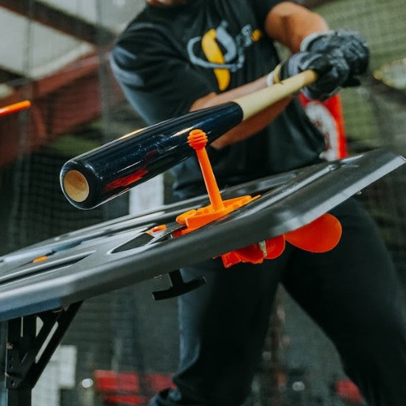 The Dry Swing Tee Topper mounted on the Swing Path Trainer during a cage session.