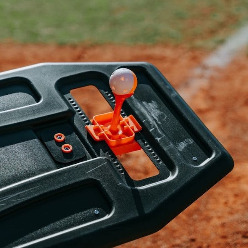 The mini topper mounted on the Swing Path Trainer holding a training ball.