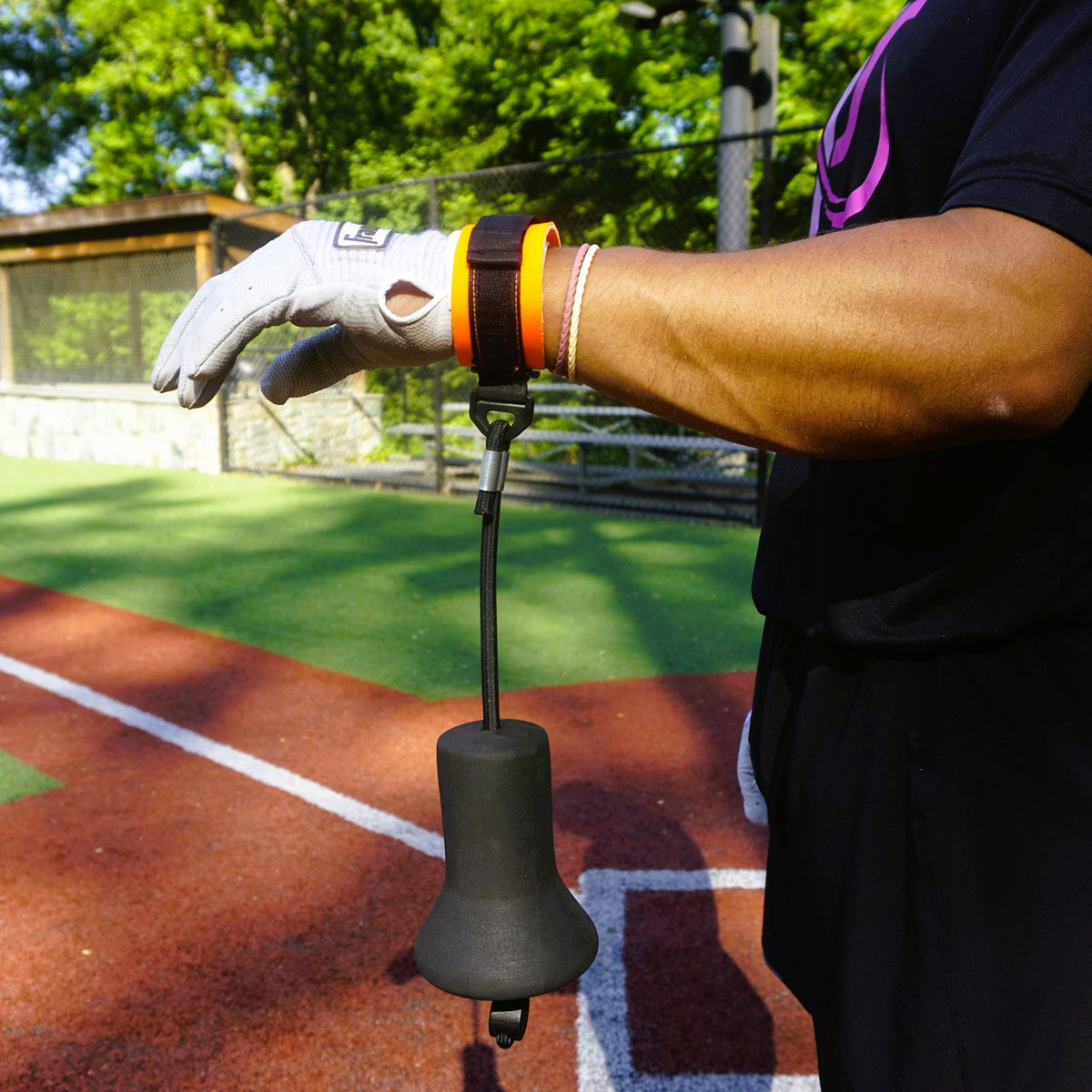 A hitter wearing the True Connect takes a swing off a training tee.