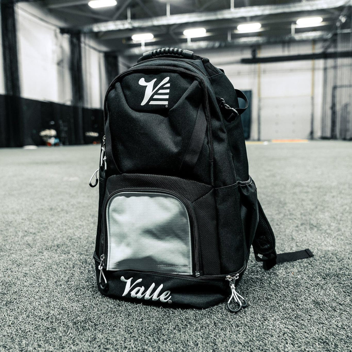 Valle Eagle Black Baseball Backpack standing on facility turf with its white center panel and bottom compartment