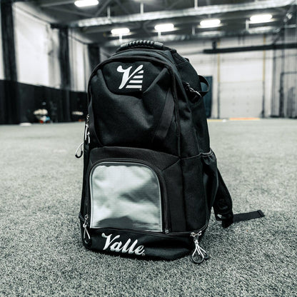 Valle Eagle Black Baseball Backpack standing on facility turf with its white center panel and bottom compartment