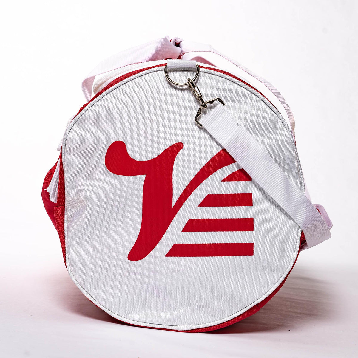 White end cap of the red Players Duffle with the red Valle V logo and clipped shoulder strap