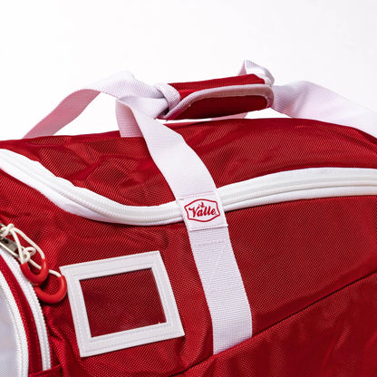 Top of the red Players Duffle showing the wrapped handles, Valle zipper tab and clear ID card window