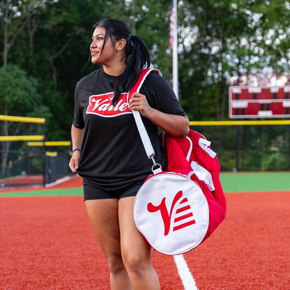 Player carrying the red Valle Eagle Players Duffle over the shoulder on the adjustable strap at an indoor field