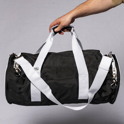 Black Valle Eagle Youth Equipment Bag held up by its two white top handles in a studio
