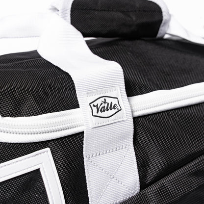 Stitched Valle tab where the white strap crosses the black fabric of the Youth Equipment Bag