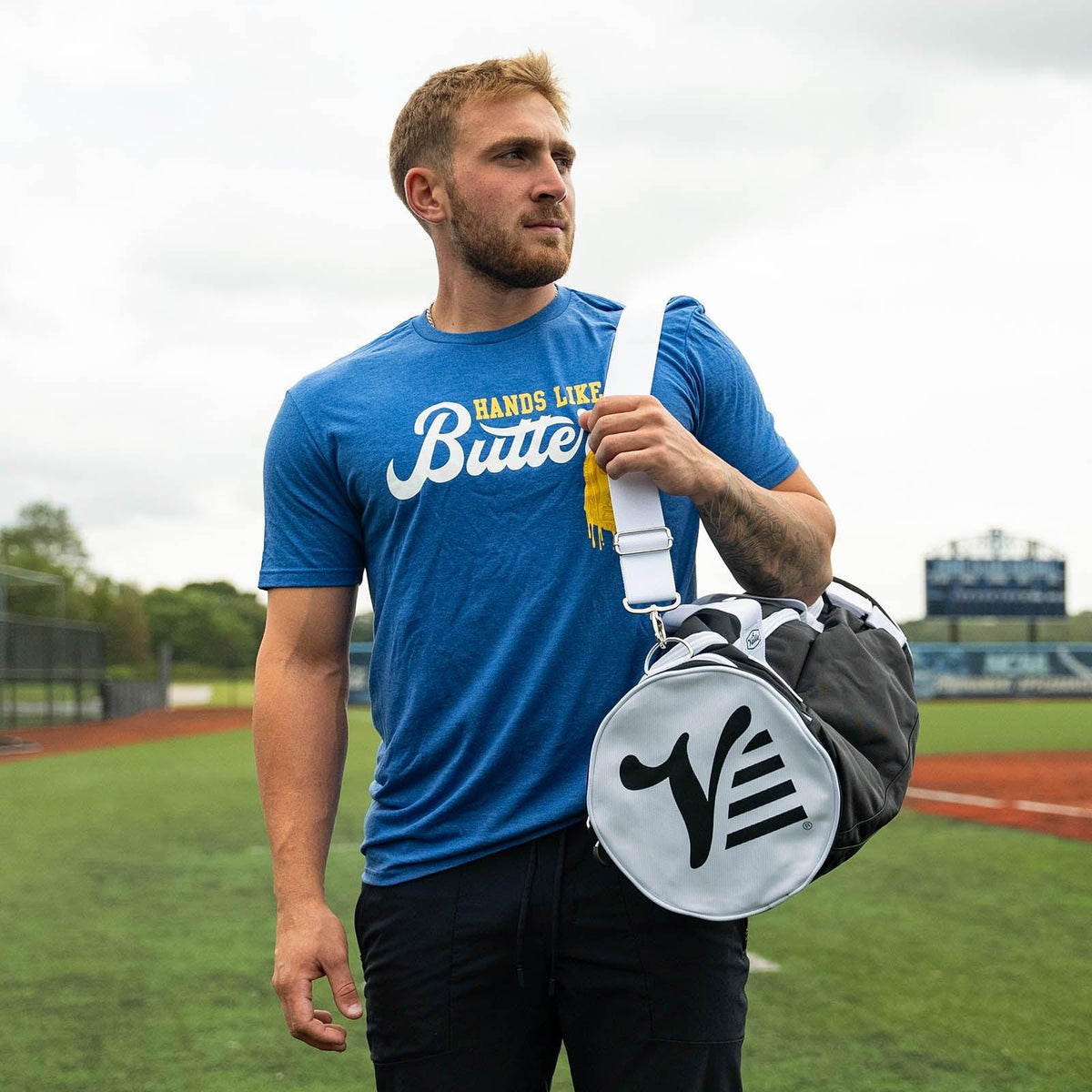 Player walking with the black Valle Eagle Youth Equipment Bag on its shoulder strap at an outdoor field
